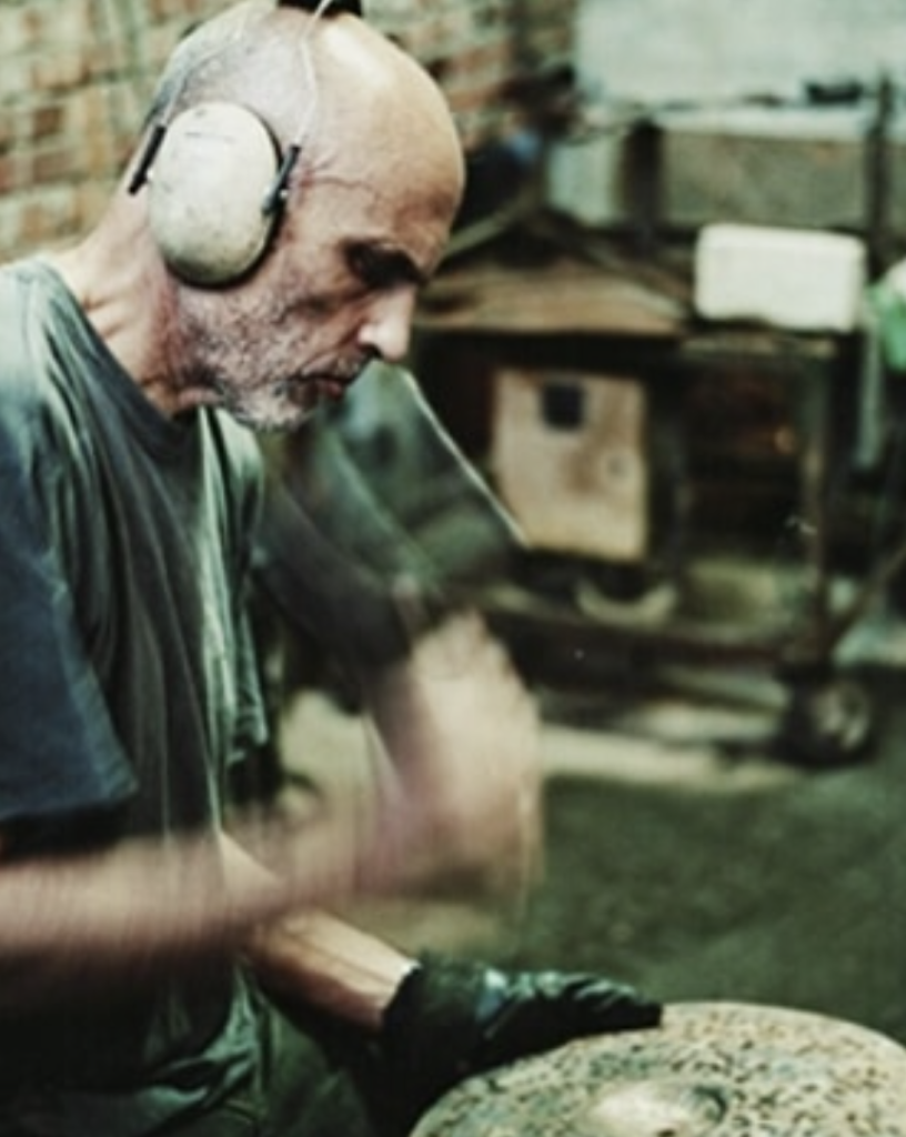 Roberto Spizzichino hammering a cymbal in his workshop in Tuscany